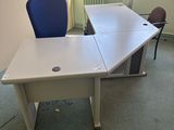 un bureau blanc avec une chaise bleue dans une pièce vide
