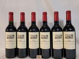 six bottles of wine are lined up on a table