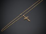un collier en or avec une croix suspendue à une chaîne