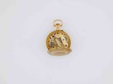 a close up of a gold pocket watch on a white surface