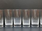 six glasses are lined up in a row on a table
