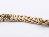 a close up of a gold chain bracelet on a white surface