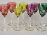 six different colored wine glasses are lined up in a row