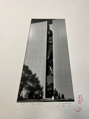 photographie en noir et blanc d'une statue devant un grand immeuble