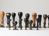 a lot of different types of wooden mallets on a white surface