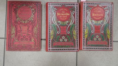 three books that are sitting on a tiled floor