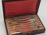 a set of six silverplated serving spoons in a wooden box