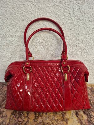 un sac à main rouge posé sur une table près d'un mur