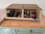 a blue cabinet with a drawer with utensils on it