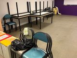 a room with chairs, tables, and a projector in it