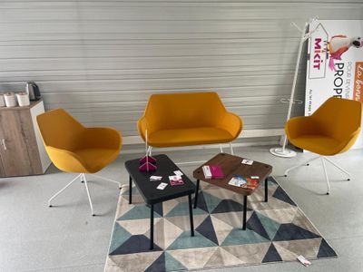 trois chaises et une table dans une pièce où il y a un tapis au sol