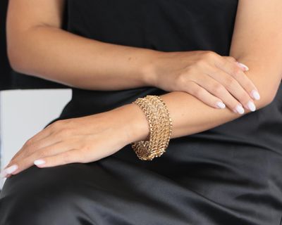 une femme assise, portant un bracelet au poignet