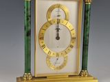 une horloge dorée et verte, avec des chiffres romains