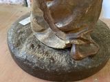 a statue of a man sitting on top of a wooden table