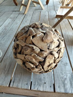 a ball of wood on a wooden table on the porch