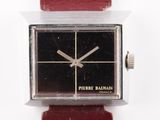 une montre posée sur un bracelet rouge