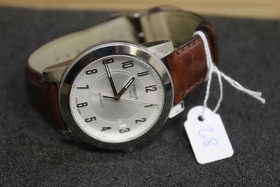 une montre munie d'une étiquette, posée sur une table