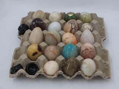 des œufs dans une boîte en carton posée sur une table blanche, sur fond blanc