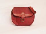 red leather purse with a metal ring on the front