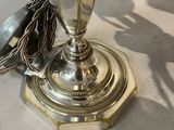 a silver vase sitting on top of a table next to a pair of scissors