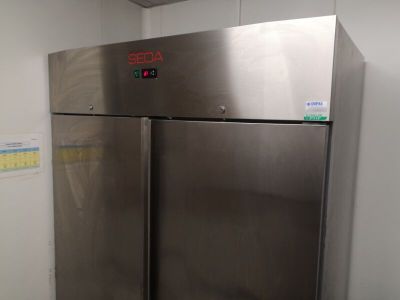 a stainless steel refrigerator in the corner of a room