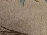a close up of a rug with a bird on it