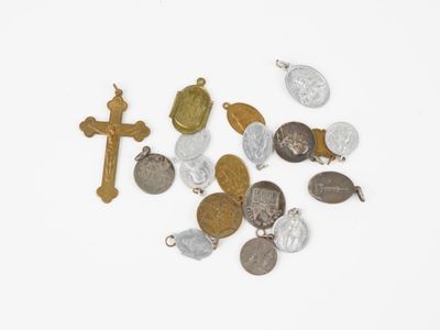quelques pièces et une croix sont posées sur une surface blanche