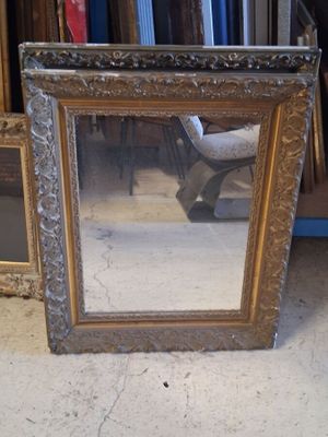 a mirror that is sitting on the floor in front of a chair