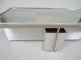 a glass table with a drawer underneath it on a white surface