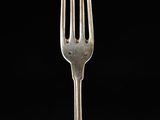 a silver fork with a black background and a black background