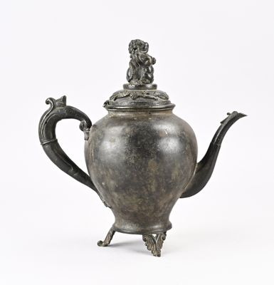 une théière en argent ornée d'un oiseau