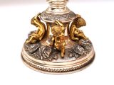 a silver and gold candle holder on a white table