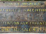 une plaque apposée sur le mur d'un immeuble sur laquelle on peut lire « don't michael veillez palentr attention aux »