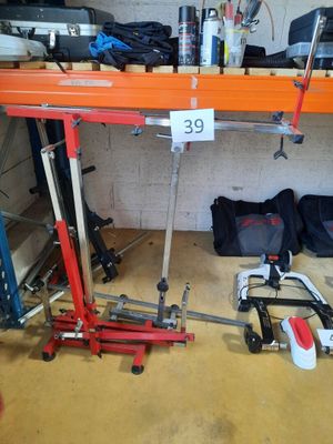 une photo d'un établi dans un garage, avec des outils posés par terre
