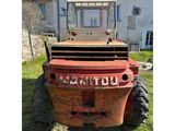 a red tractor that is parked in the grass