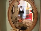 a small table with a mirror on it and a bird figurine on top of it