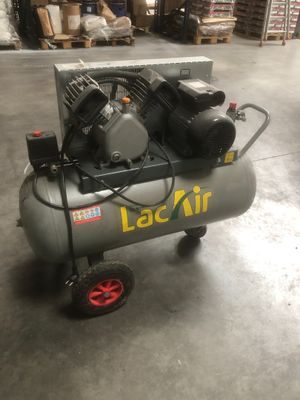 un petit compresseur d'air posé sur un chariot dans un entrepôt