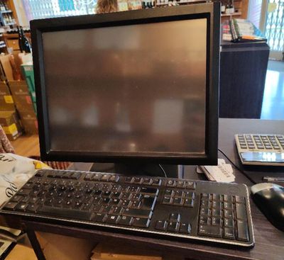 un écran d'ordinateur et un clavier posés sur un bureau dans un magasin
