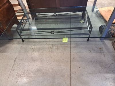 une table basse en verre surmontée d'un piètement en métal