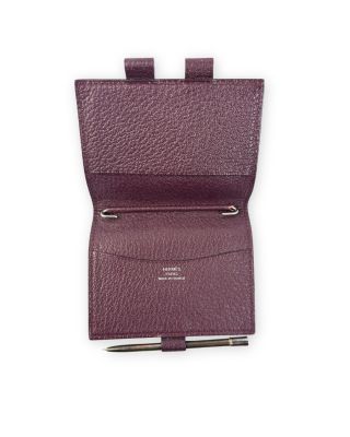 un gros plan d'un portefeuille violet contenant un stylo