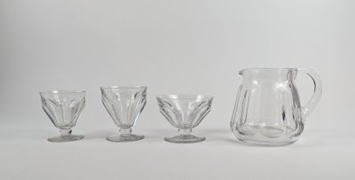 trois verres transparents et un pichet posés les uns à côté des autres sur une surface blanche