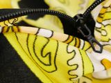 a close up of a yellow and black bag with a butterfly on it