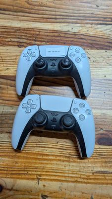 deux manettes de jeux vidéo posées sur une table en bois