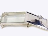 a silver tray with a mirror in it on a white surface
