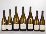 six bouteilles de vin sont alignées sur une table