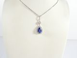 un gros plan d'un collier porté par un mannequin, orné d'un pendentif bleu en forme de larme