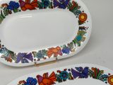 two plates with colorful designs on them on a table