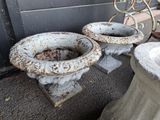 deux urnes en ciment placées l'une à côté de l'autre sur le trottoir