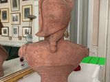 a bust of a woman sitting on a table in front of a mirror