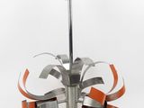 an image of a metal sculpture with orange ribbons on it